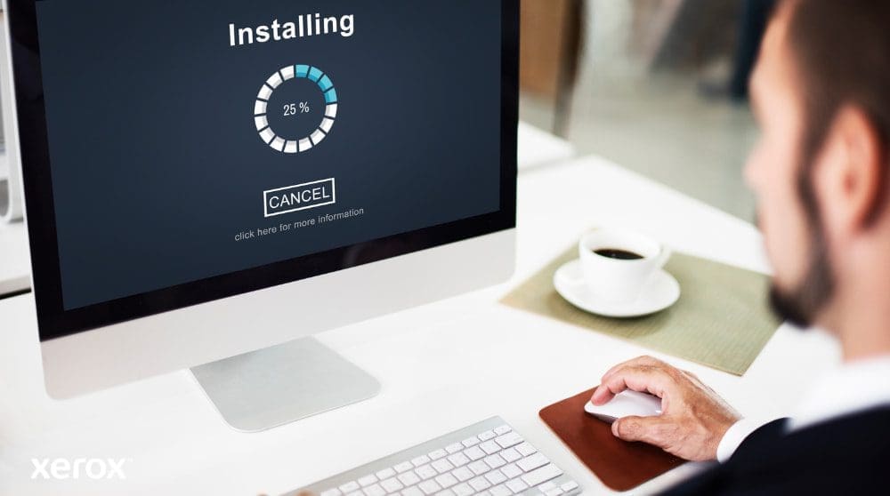 Una vista de cerca de un monitor de computadora que muestra una barra de progreso de "Instalación" al 25%, con la mano de una persona sobre un mouse de computadora al lado de una taza de café, lo que ilustra una fácil configuración del software.